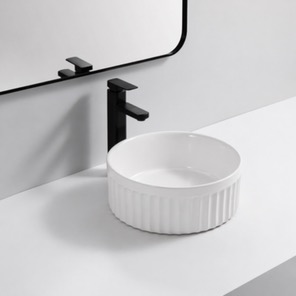Lavabo Les Coves de Vinromà — Lavabo redondo estriado blanco sobre encimera.