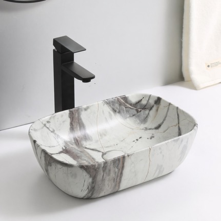 Lavabo Sarratella — Lavabo sobre encimera efecto mármol blanco veteado.